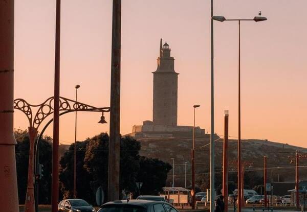 Torre de Hércules sobre un cielo rosado, creando un ambiente romántico